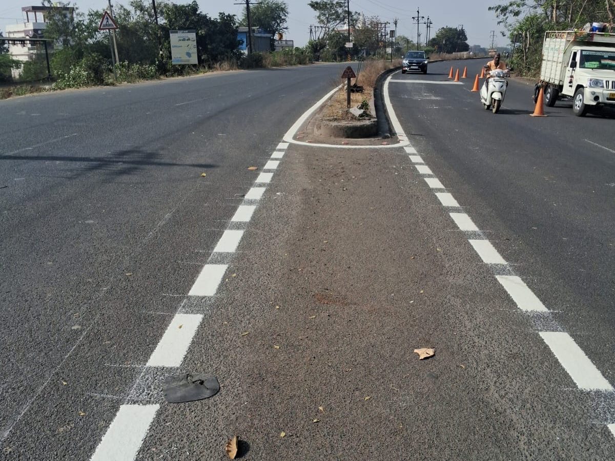 Freshly painted lane and median markings where the divided road opens near Chichala
